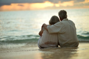 Elderly couple watching the sunset on a beach